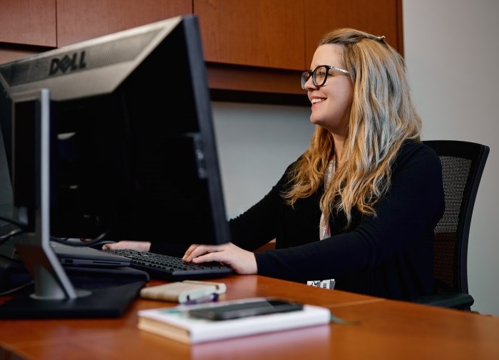 woman sitting at desk smiling