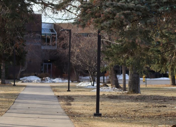 sidewalk through doug mcrae park in spring with mostly melted snow