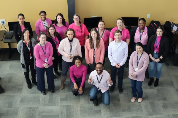 group of staff members wearing pink shirts.