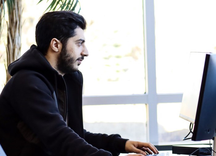 male student sitting at computer desk