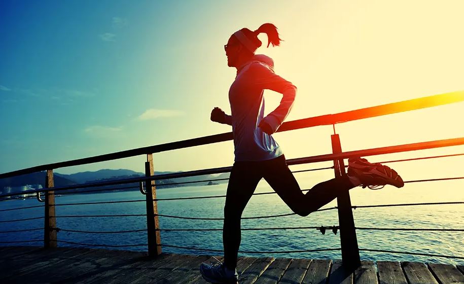 woman running for exercise on a dock by water