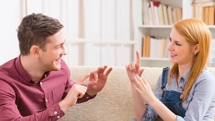 man and woman using their hands to speak sign language to each other