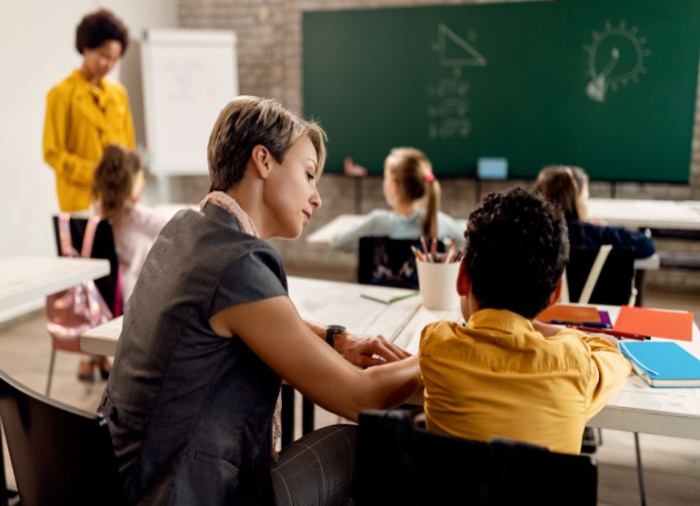 educational assistant assisting student in classroom