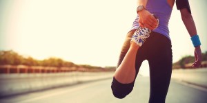 a woman stretching and running on a road