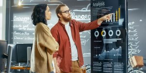 two workers planning marketing endeavours on a board.