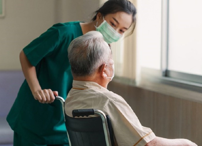 health care aide speaking with patient in wheelchair