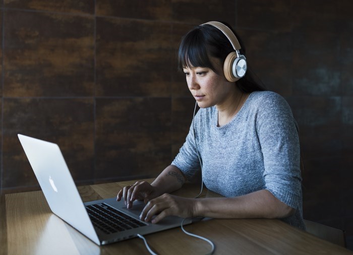 Woman with headphones on using a computer