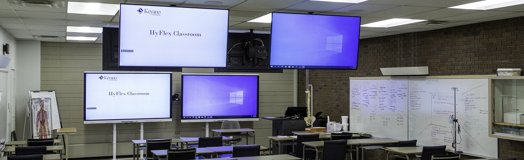 View from the back of a hyflex classroom. Shows screens and smart podium