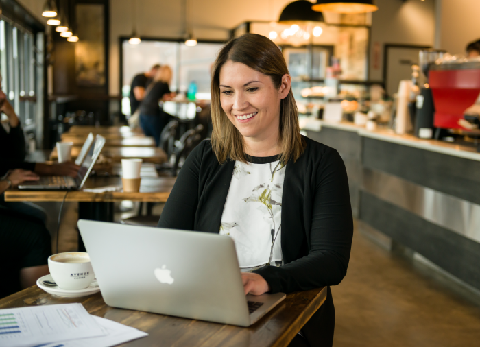 Woman sitting with a laptop in a coffee shop