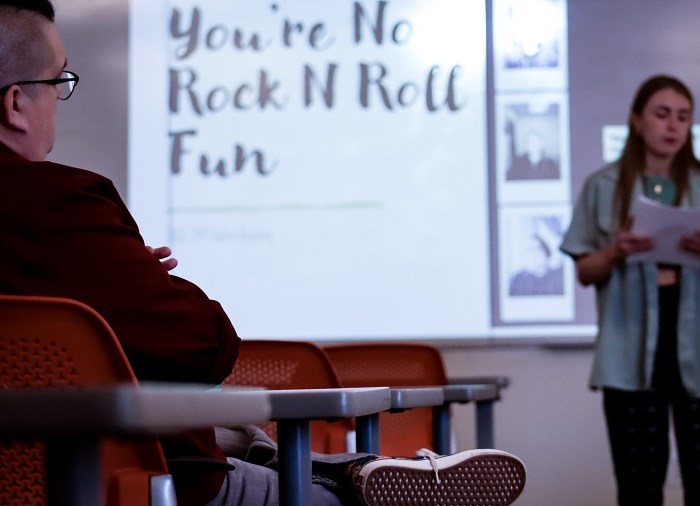 teacher listening to student read poetry