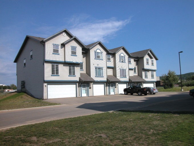 A series of blue townhouses on a sunny day