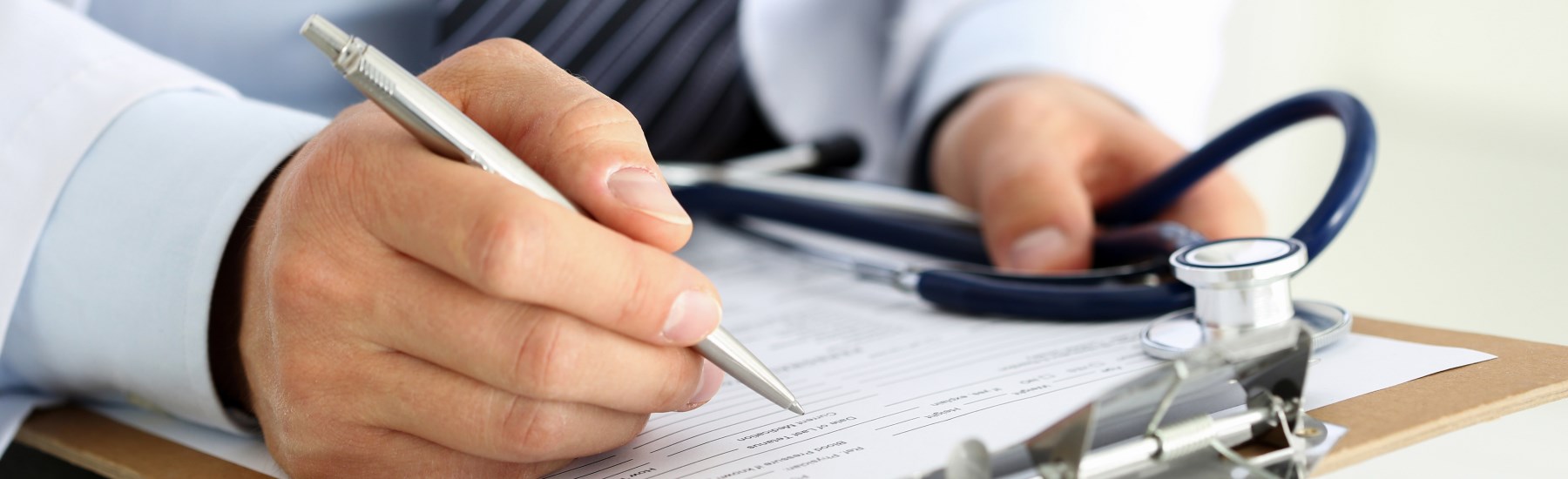 Hands and stethoscope on desk