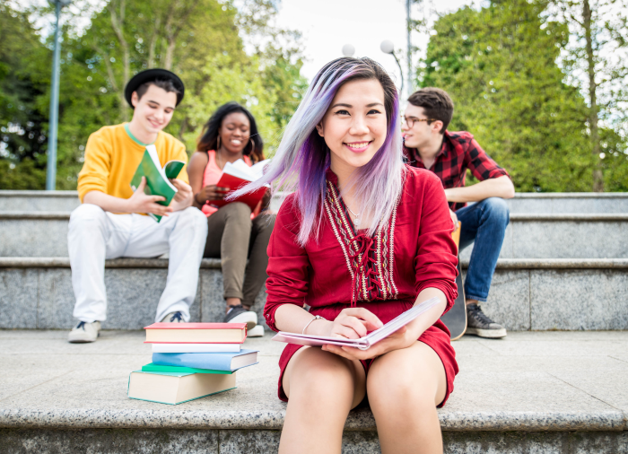 student smiling with students studying in background