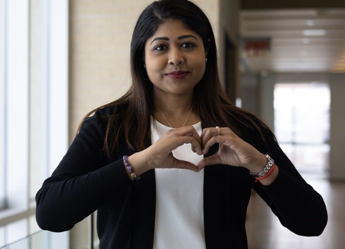 Student Emily with hands in heart shape formation.