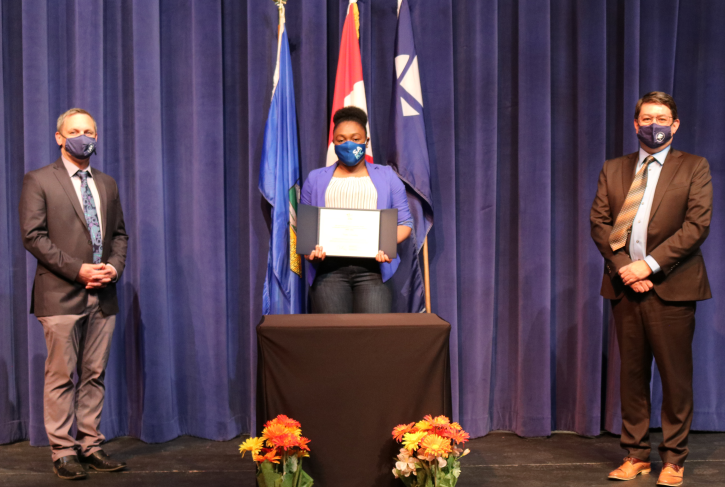 Naika Dunkley holding governor general award presented by VP Fred Russell and Interim president Daley Mountain