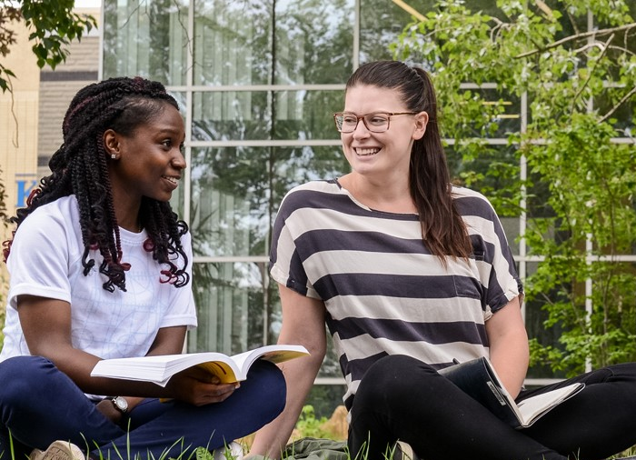 students on lawn smiling and talking