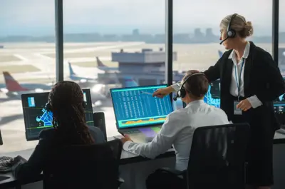 Airport operations personnel monitor flight and operational data from a control centre overlooking the airfield. Team members use headsets and computer systems to coordinate airport activities, demonstrating careers in airline and aviation operations management.