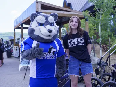 Keyano Huskies mascot with a female student athlete posing for picture