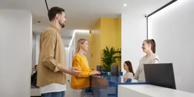 Man and woman couple talking to receptionist at family clinic center
