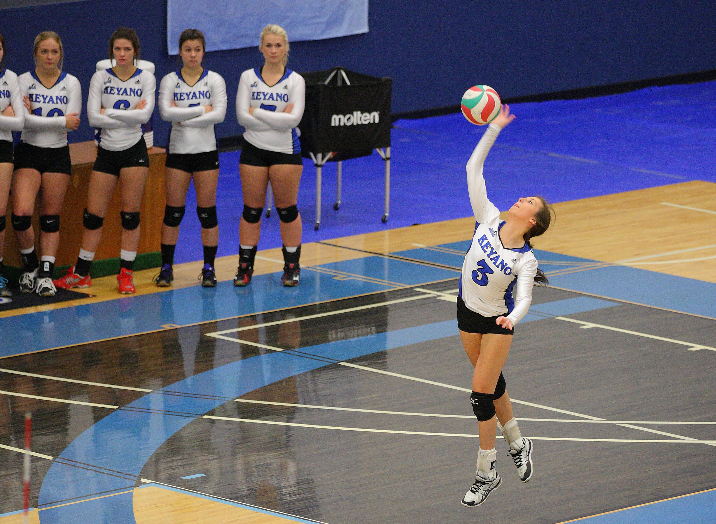 A girl serving and four people watching