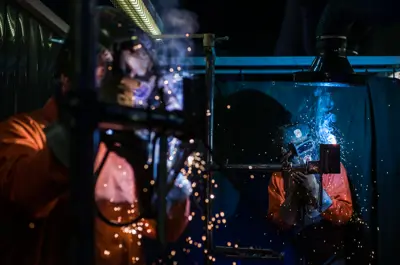 Millwright wearing safety gear repairing machinery in an industrial setting