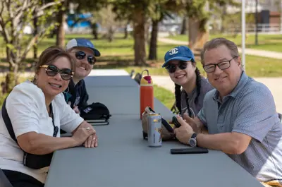 four people sitting at a table smiling at the camera
