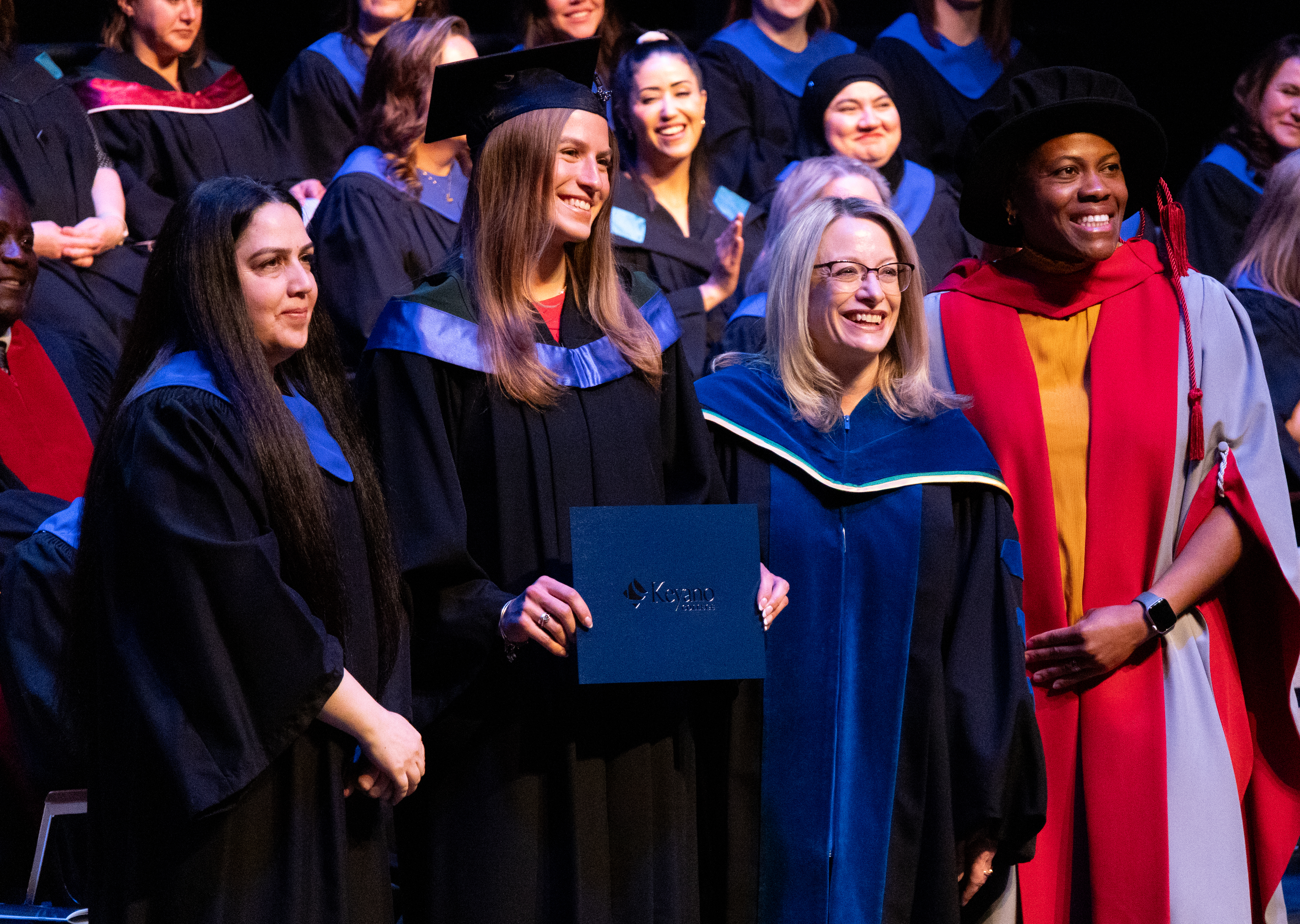 A graduated student holding her degree certificate with Nada Al-Khaladi, a faculty, and Dr. Sandra Efu standing next to her