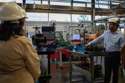 Instructor demonstrating power plant equipment to students during a hands-on Power Engineering lab session